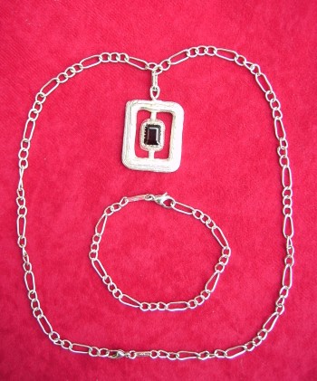 Garnet mounted and supported on a fetter and link chain, with matching chain bracelet